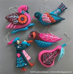 four colorful birds hanging from strings on a gray surface with text overlay that says, ` `