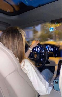 a woman driving a car while holding the steering wheel