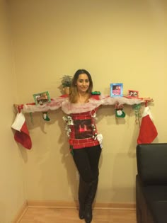 a woman standing in front of a wall with christmas stockings on her arms and legs