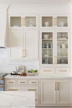 a kitchen with white cabinets and gold trimmings on the doors is featured on instagram