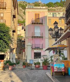 an old fashioned cart is parked on the street in front of some buildings with balconies