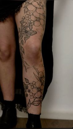 a woman's legs with flowers and leaves on them