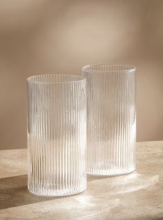 two clear glass vases sitting on top of a table