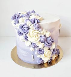 a purple and white cake with flowers on top