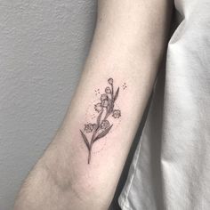 a small flower tattoo on the arm