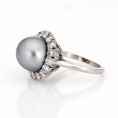 This is part of Chairish’s Fine Jewelry assortment.  Finely detailed vintage Van Cleef & Arpels South Sea Pearl & diamond ring crafted in platinum (circa 1980s to 1990s).   South Sea Pearl measures 11mm. 16 diamonds total an estimated 1.20 carats (estimated at E-F colour and VVS2 clarity). The pearl is lustrous with a light gunmetal grey colour & soft peacock rose overtones.   The mounting is made by Van Cleef & Arpels, signed and numbered with a special designation of "mtg only" for mounting on Timeless Diamond Pearl Ring With Center Stone, White Gold Formal Ring With Center Stone, White Gold Ring With Center Stone For Formal Occasion, Fine Jewelry Platinum Cluster Ring, Formal Brilliant Cut Pearl Ring In Platinum, Round Diamond Pearl Ring, Fine Jewelry Platinum Cluster Ring With 17 Jewels, Formal Platinum Halo Ring With Diamond Accents, Formal 14k White Gold Ring With Round Stone