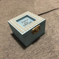 a small wooden box with pearls on the inside and an inscription above it that reads ahoh ohana