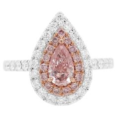 This beautiful ring features an amazing Pear-shaped Pink diamond at its forefront, accentuated by shimmery pink diamond and white diamond halos. Set in 18 Karat white gold to enrich the spectacular hues of the pink diamonds and the glistening of the white diamonds, this ring utilizes a mesmerizing combination. - Centre Diamond, GIA Certified Pear Shape Pink Diamond 0.39 carat (color Fancy Orangy Pink, clarity SI1, certificate GIA 2376221111) - Round Brilliant Cut Argyle Pink Diamonds total 0.14 carat - Round Brilliant Cut White Diamonds total 0.39 carat (color E-F, clarity VVS-VS) - Made of 18K White and Pink Gold - Ring Size US6 (can be sized upon request) Argyle mine in Western Australia takes care of over 90% of the demand for pink diamonds in the world and was closed in Nov 2020 which 18k Gold Engagement Ring, Pink Gold Rings, Argyle Pink Diamonds, Pink Diamond Ring, Contemporary Engagement Rings, Platinum Rose Gold, Fancy Color Diamonds, Timeless Jewelry, Rose Gold Diamonds