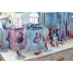 several frozen princess bags are sitting on a table with other items in front of them