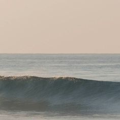 a man riding a wave on top of a surfboard in the middle of the ocean