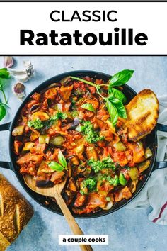 a skillet filled with ratatoulie and topped with fresh basil, parsley and garlic