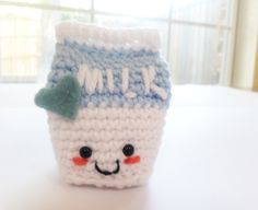 a crocheted coffee cup with a smile on it's face is sitting on a table