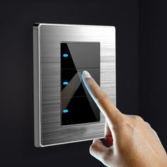 a hand is pressing the button on a wall mounted light switch that has blue lights