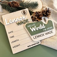 a wooden sign that says lenox wade next to some pine cones on a table