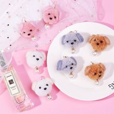 small stuffed animals are on a plate next to a bottle of perfume and necklaces