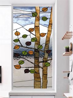 a glass window with leaves on it in a living room next to a white wall