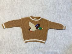 Mallard Duck hand embroidered on soft knit baby sweater.  Personalization options available.  If the color/size you want is not listed, message me and I can try and make what you want. The sweaters run large. *Actual item may vary from photo slightly due to hand embroidery. Embroidered Knit Long Sleeve Sweater, Embroidered Long Sleeve Knit Sweater, Embroidered Crew Neck Knit Sweater, Embroidered Long Sleeve Cozy Sweater, Cozy Long Sleeve Embroidered Sweater, Handmade Long Sleeve Top For Fall, Cute Long Sleeve Embroidered Sweater, Handmade Brown Sweater With Long Sleeves, Cute Custom Embroidered Sweater For Winter