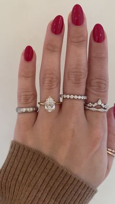 a woman's hand with three different rings on it