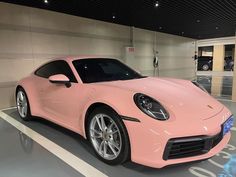 a pink sports car parked in a showroom