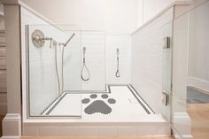 a walk in shower with black and white designs on the floor