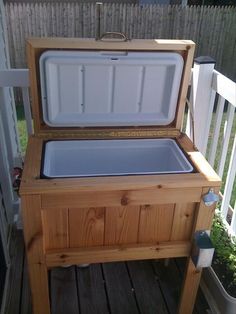 an outdoor cooler sitting on top of a wooden table