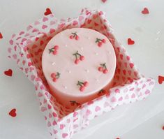 a pink cake in a box with hearts on it