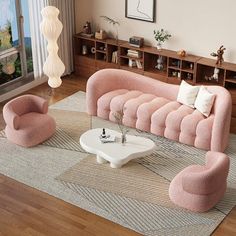 a living room with pink couches and white coffee table in front of a large window