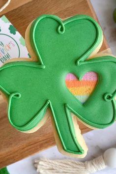 a cookie shaped like a shamrock with a heart in the shape of a rainbow on it