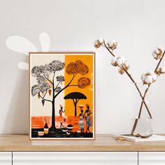 an art print is displayed on a shelf next to a vase with cotton flowers in it