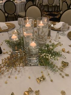 a table with candles and flowers on it in front of some gold foil confetti