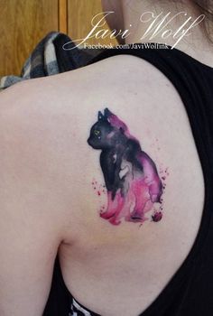 a cat tattoo on the back of a woman's left shoulder, with pink and black ink