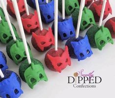 there are many colorful cake pops with toothpicks in the shape of cats on them