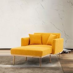 a yellow chair sitting on top of a wooden floor next to a white and gray wall