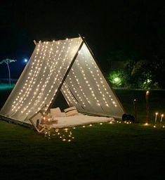 a tent that has lights on it in the grass