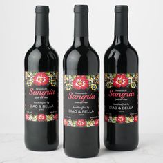 three bottles of red wine sitting on top of a table