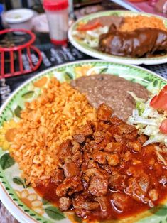 two plates with different types of food on them sitting on a table next to each other