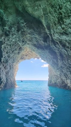 the water is blue and clear as it passes through an opening in a rock formation