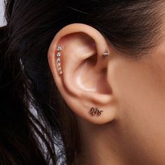 a close up of a person wearing ear piercings with the word love written on it