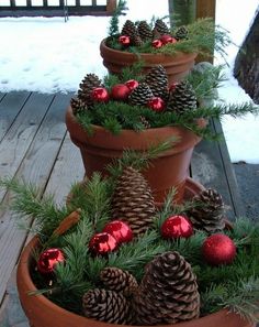 a christmas tree made out of pine cones and red baubles in a pot