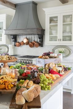 a kitchen filled with lots of food on top of a wooden cutting board next to an oven