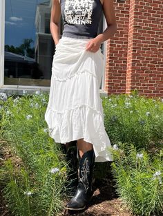 vintage, vintage tee, cowboy boot, flowy skirt, white skirt, flowy white skirt, cowboy boots, black cowboy boots, cowboy boot outift, white skirt outfit, spring outfit, vitage tee outfit, cool girl fit, flowers, white, simple jewelry White Skirt Cowboy Boots, Cowgirl Boots And Dress Outfit, Skirt And Cowboy Boots Outfit, Skirt Cowboy Boots, Skirt Outfit Spring, Skirt Outfits With Boots, White Flowy Skirt, White Skirt Outfit, Black Cowboy Boots Outfit