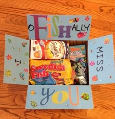 an open box filled with candy on top of a wooden table next to a sign that says, fish ally