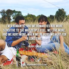 a man and woman sitting on top of a grass covered field next to each other