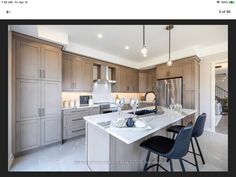 a large kitchen with an island in the middle and two chairs at the counter top