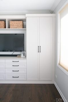 an empty room with white cabinets and drawers