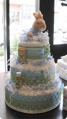 a diaper cake with a teddy bear on top