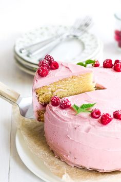 a cake with pink frosting and raspberries on top