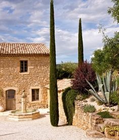 a stone building with two tall trees in front of it