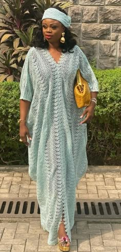 a woman in a blue crochet dress and yellow purse