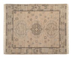 an antique rug with fringes and medallions on the center, in beige tones